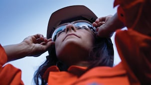 Vrouwelijke medewerker houdt zonnebril vast op haar neus