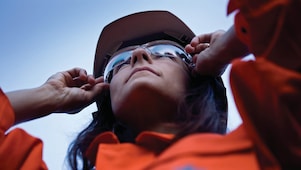 Vrouwelijke medewerker houdt zonnebril vast op haar neus