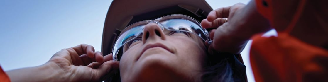 Vrouwelijke medewerker houdt zonnebril vast op haar neus