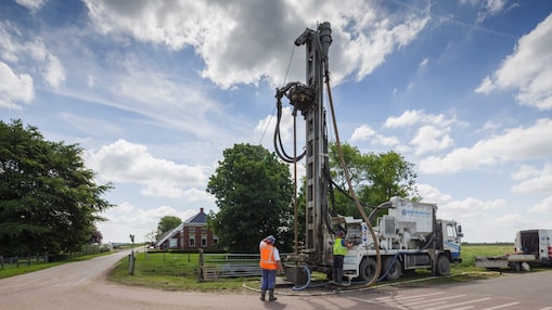 Een hand pakt de Telegraaf uit een rek