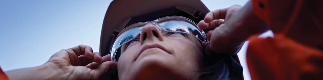 Vrouwelijke medewerker houdt zonnebril vast op haar neus