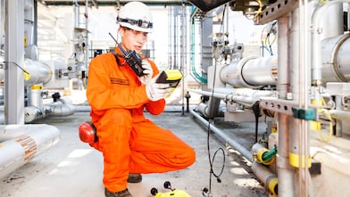 Man in oranje overall bestudeert een meter