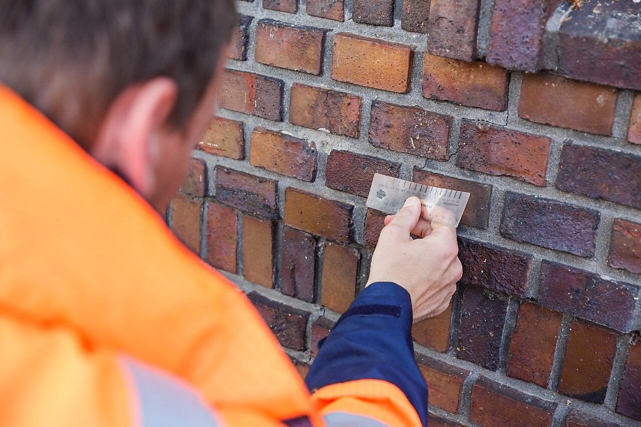 Man measuring the wall