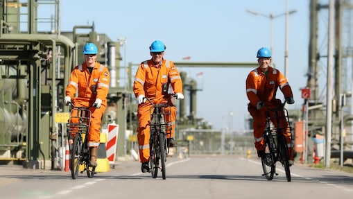 Drie medewerkers fietsen over het bedrijfsterrein