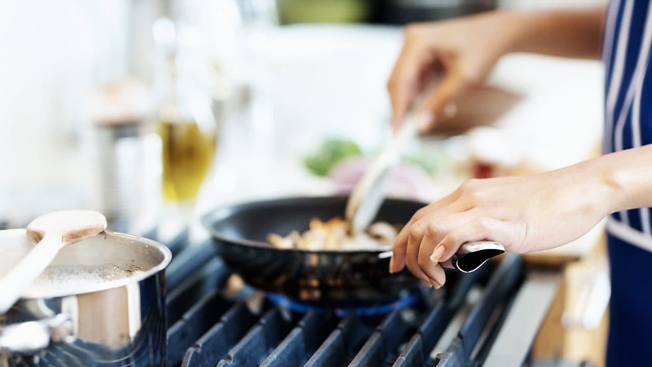 Twee pannen op een fornuis waaraan gekookt wordt