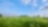 Blauwe lucht en groen gras met in de verte een gaswinningslocatie