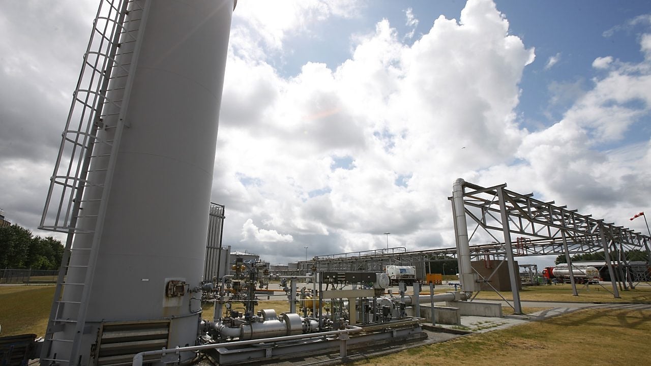 Een kind achterstevoren op een stoel met zijn wang leunend tegen de leaning met op de achtergrond een radiator