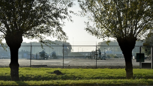 Twee bomen, met daarachter een gasproductie locatie