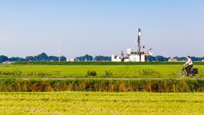 Groen weiland met fietser op fiets pad, in de verte een winningslocatie