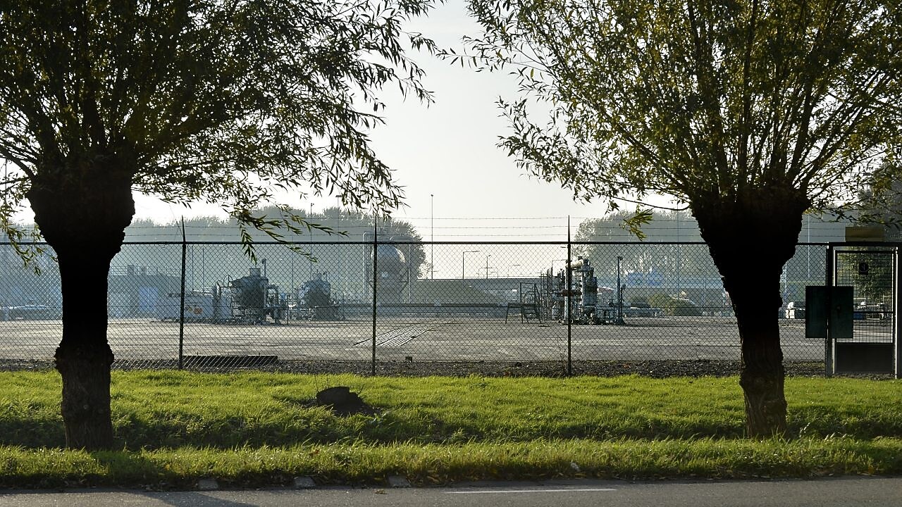 Twee bomen, met daarachter een gasproductie locatie