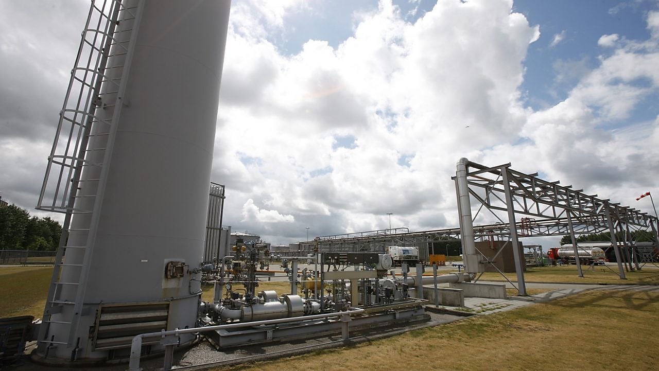 Een kind achterstevoren op een stoel met zijn wang leunend tegen de leaning met op de achtergrond een radiator