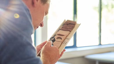 Man bestudeert grondmonsters met een loep