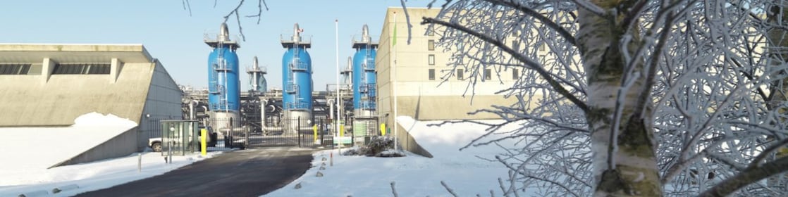 Blauwe gebouwen van de gasopslag in sneeuwlandschap