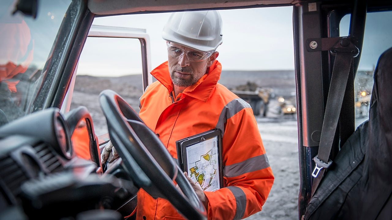 Man in oranje overall met tablet