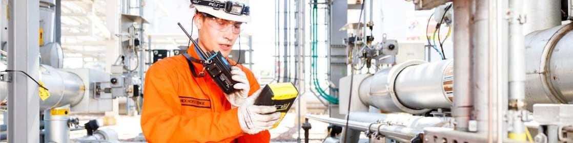 Man in oranje overall bestudeert een meter