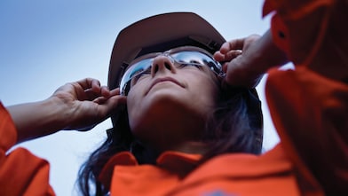 Vrouwelijke medewerker houdt zonnebril vast op haar neus