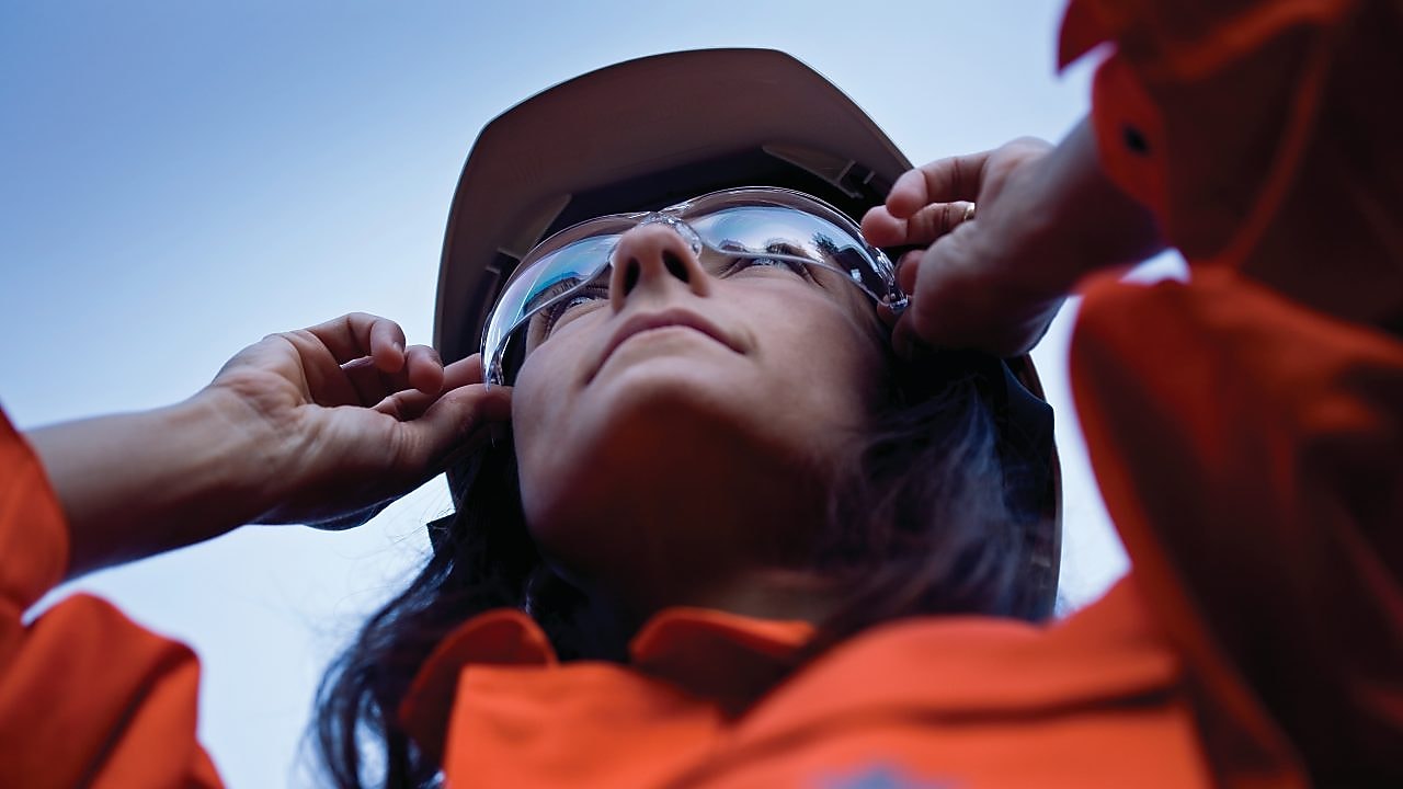 Vrouwelijke medewerker houdt zonnebril vast op haar neus