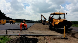 Medewerkers asfalteren een terrein met asfalteermachine