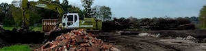 Graafmachine bij afgegraven grond met berg puin